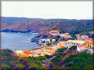 Vista de la pequeña población de cala Es Murta, con su característica costa negra por la piedra de pizarra negra que esta parte de la costa de Menorca